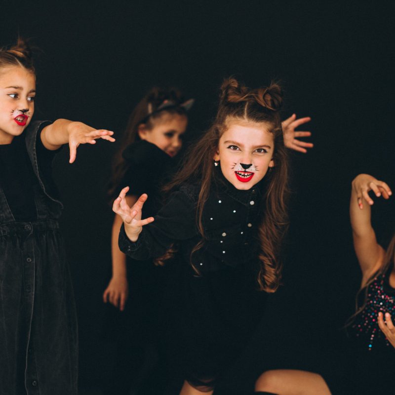 Group of girls dressed in halloween costumes in studio